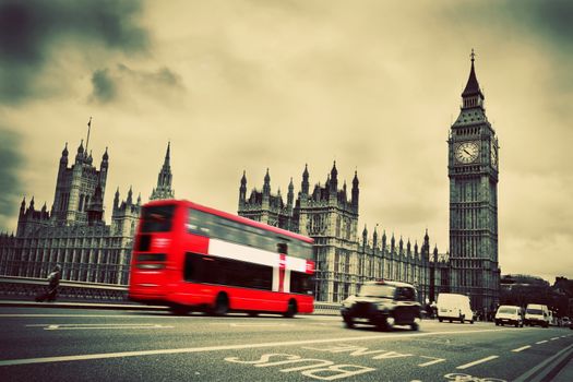 London, the UK. Red bus in motion and Big Ben, the Palace of Westminster. The icons of England in vintage, retro style