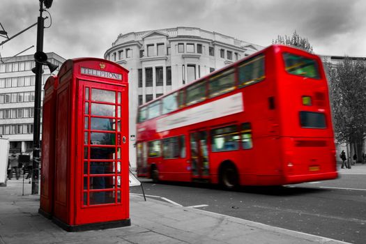 London, the UK. Red phone booth and red bus in motion. English icons