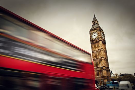 London, the UK. Red bus in motion and Big Ben, the Palace of Westminster. The icons of England