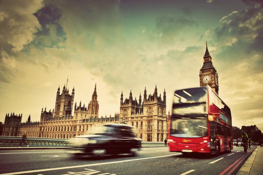 London, the UK. Red bus, taxi cab in motion and Big Ben, the Palace of Westminster. The icons of England in vintage, retro style