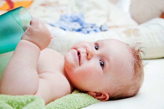 A baby waiting for changing his napkin, lying on bed