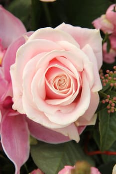 Soft pink rose and orchid in a bridal bouquet