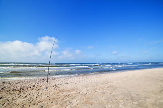 Fishing rod on the beach. Fishing in the sea. Blue sky