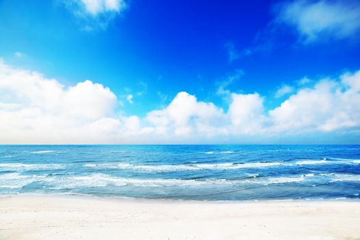 Hot summer beach, sea scenery. White sand, blue sunny sky, waves.. Holidays time