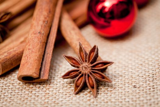 christmas decoration cinnamon anise baubles in red macro closeup