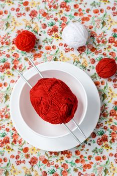 White plate, the spokes, red and white ball on the background of a red flower