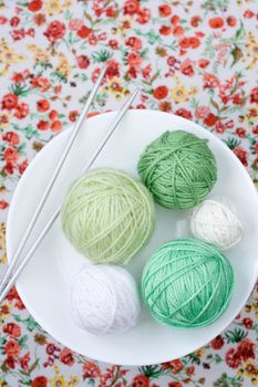A lot of bright balls of knitting on the background of a red flower