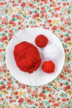 White plate, the spokes, red and white ball on the background of a red flower