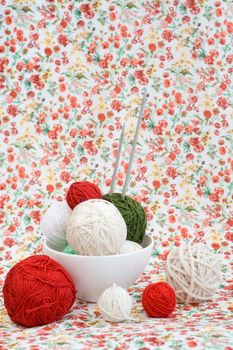 A lot of bright balls of knitting on the background of a red flower