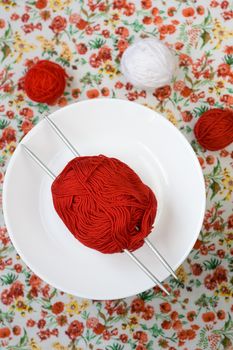 White plate, the spokes, red and white ball on the background of a red flower
