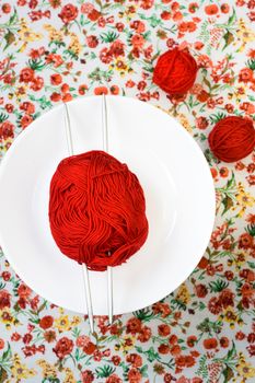 White plate, the spokes, red and white ball on the background of a red flower