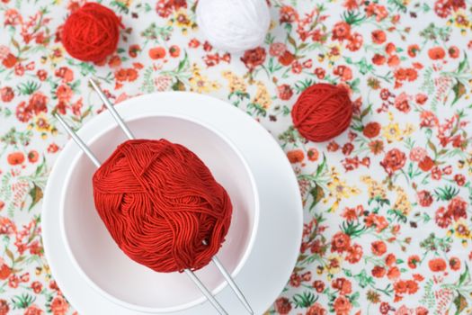White plate, the spokes, red and white ball on the background of a red flower