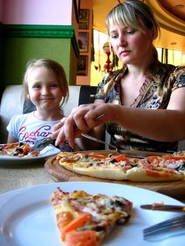 image of mother and daughter eating in pizzeria