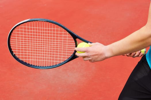 Player on hard court ready to serve the tennis ball with racket