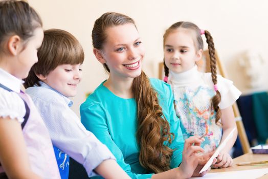 children draw with the teacher in the classroom drawing