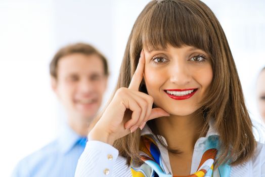 Portrait of a young successful business woman standing against colleagues