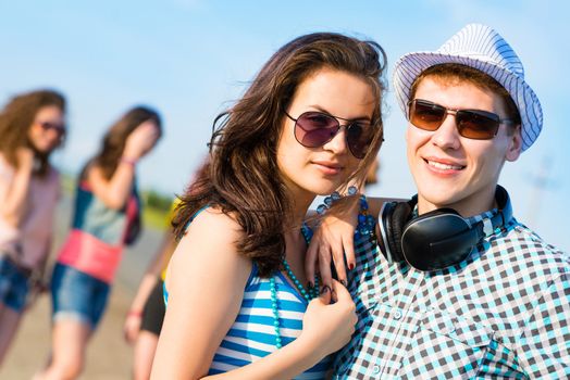 young couple standing on the road, having fun with friends