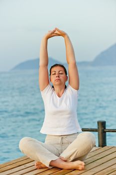 girl on the pier is engaged in gymnastics