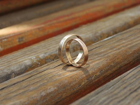 Two wedding rings on a wooden bench                          