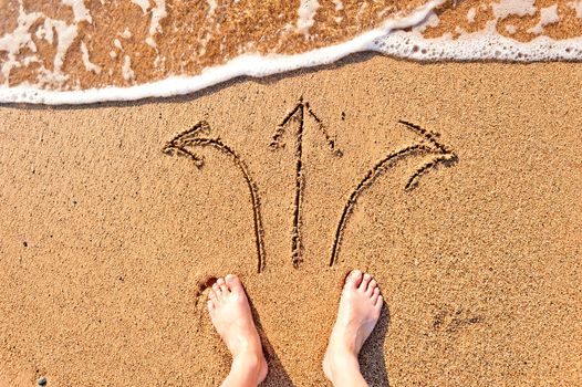 men's bare feet in the sand and arrows