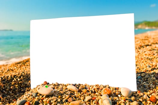 blank sheet of paper on a beach against the sea