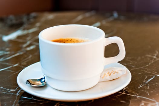 Coffee in a white cup on a marble table