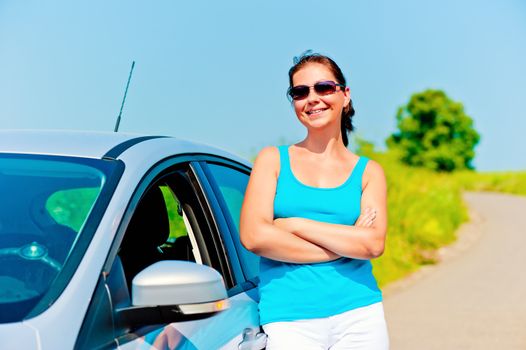 beautiful young woman stands near the new car