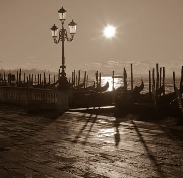 Gondolas in sun light. Sepia image of Venice