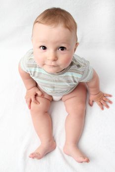 beautiful laughing baby sitting on white bed