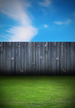 backdrop of backyard with old black wooden fence and green grass