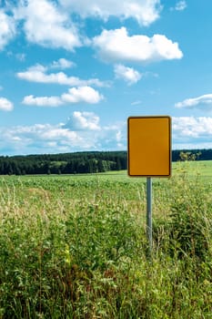 signpost with blue sky and green field, rural landscape scene