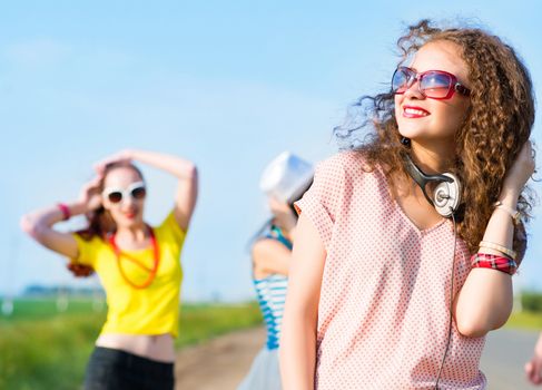 young woman with headphones on a background of blue sky and funny friends