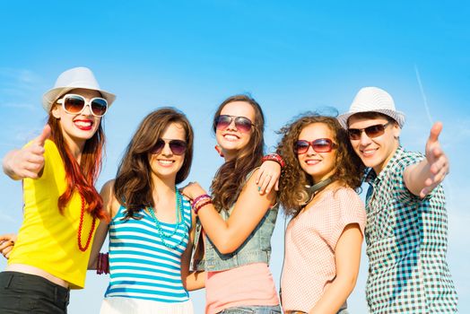 group of young people wearing sunglasses and hats hugging and standing in a row, spending time with friends