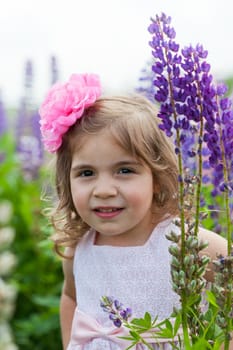 girl to stand among blossoming lupines
