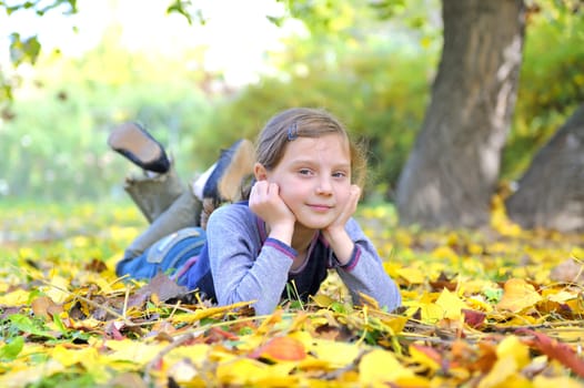 little girl lays on the leaves