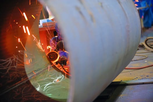 naval welder with protective mask welding metal and sparks