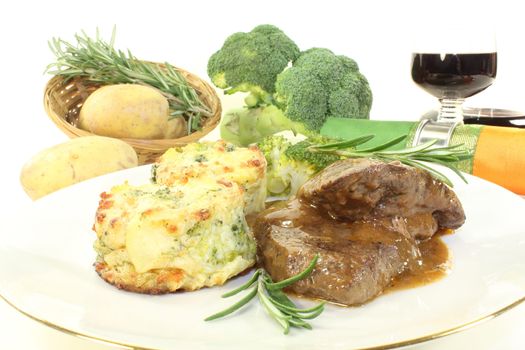 Venison medallions with potato gratin on a light background