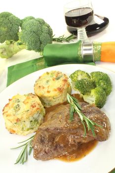 Venison medallions with potato gratin and rosemary on a light background