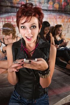 Surprised pretty young woman holding a smart phone