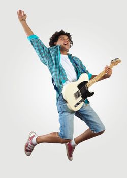 young man playing on electro guitar and jumping