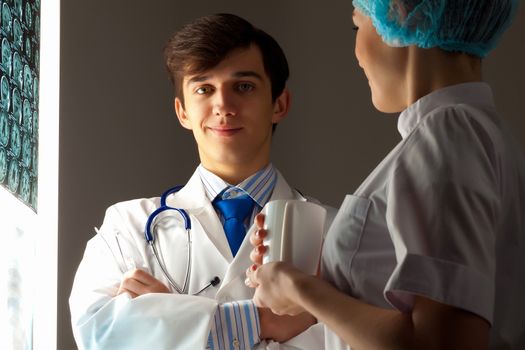 Image of two young two doctors discussing x-ray results