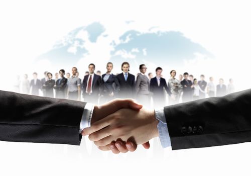 business handshake against white background and standing businesspeople