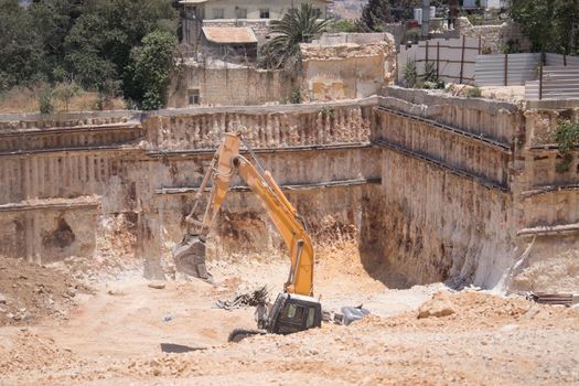 Backhoe dumping dirt on the ground.