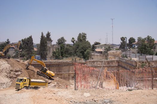 Two backhoes clearing a site after a building demolition.