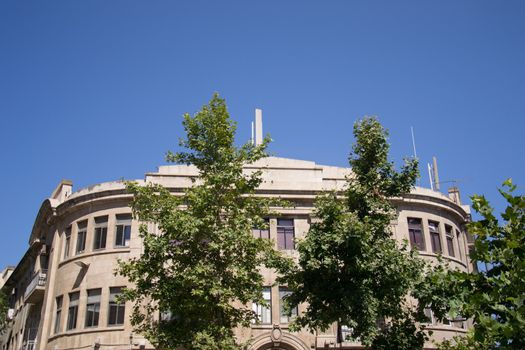 Old brick building against a clear blue sky with trees