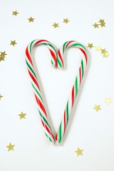 Two candy canes come together in the spirit of the holidays to make a heart shape.