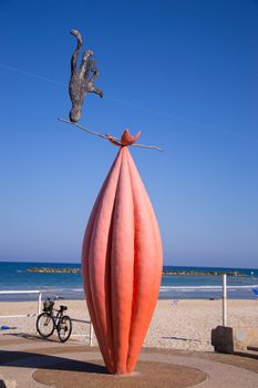 Statue of animal juggler lon a beach