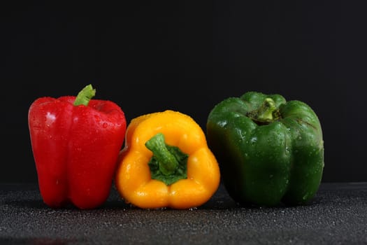 three fresh sweet pepper isolated on black background