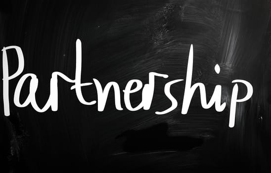 The word 'Partnership' handwritten with white chalk on a blackboard