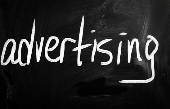 The word "advertising" handwritten with white chalk on a blackboard